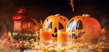 Cadılar Bayramı turuncu şenlikli içki tatlı Mısır, düşen yapraklar ve saman, seçici odak vintage ahşap sonbahar zemin üzerine 