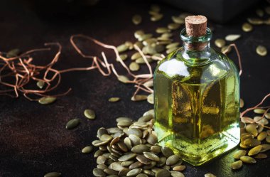 Kabak çekirdeği yağı cam şişe, karanlık tablo, seçici odak şifa