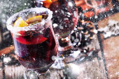 Yeşil çam dalları ve ışıklar, rustik ahşap masa, seçici odak arka plan üzerinde star Noel ve yeni yıl festival içki, tarçın, kakule, portakal ve anason ile sıcak mulled şarap