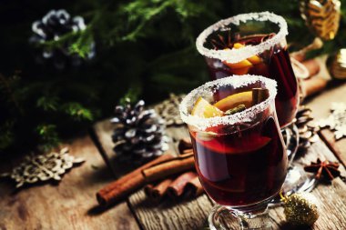 Yeşil çam dalları ve ışıklar, rustik ahşap masa, seçici odak arka plan üzerinde star Noel ve yeni yıl festival içki, tarçın, kakule, portakal ve anason ile sıcak mulled şarap