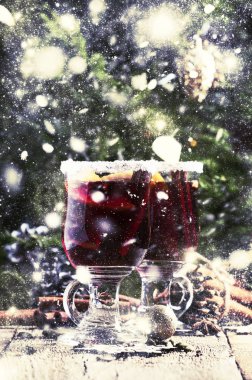 Yeşil çam dalları ve ışıklar, rustik ahşap masa, seçici odak arka plan üzerinde star Noel ve yeni yıl festival içki, tarçın, kakule, portakal ve anason ile sıcak mulled şarap
