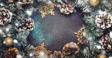 Yeşil kar köknar dalları, çam kozalakları, altın kar tanesi, Noel topları, kırmızı meyveler ve çalar saat kahverengi zemin, üstten görünüm Noel ve yeni yıl çerçeve kompozisyonu