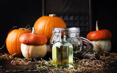 Kabak çekirdeği yağı cam şişe, karanlık tablo, seçici odak şifa