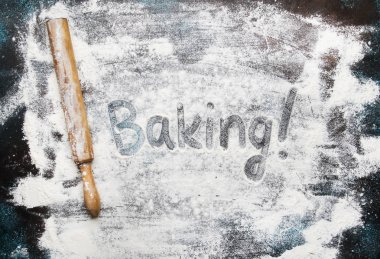 Yiyecek ya da fırın arka plan, beyaz un karanlık tabloyu, eski ahşap oklava, pişirme, yazıt üstten görünüm ile serpilir