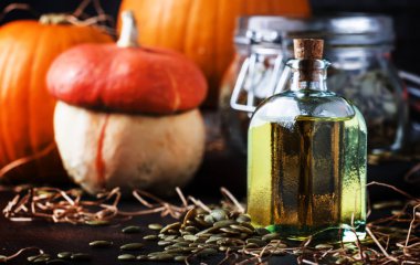 Kabak çekirdeği yağı cam şişe, karanlık tablo, seçici odak şifa