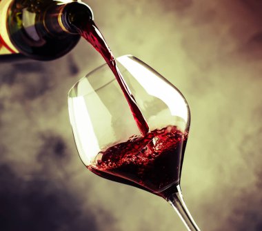 Fransız kuru kırmızı şarap, cam, gri arka plan, seçici odak dökülen