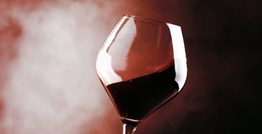 Kırmızı şarap, bir bardak sıçrama kuru cabernet sauvignon, koyu kırmızı arka plan, hareketli resim, sığ derinlik-in tarla defocused