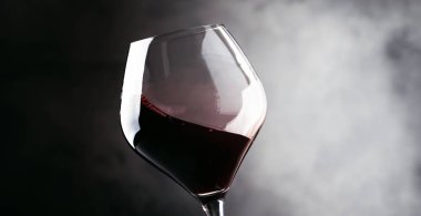 Kırmızı şarap, bir bardak sıçrama kuru cabernet sauvignon, koyu arka plan, hareketli resim, sığ derinlik-in tarla defocused