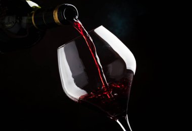 Büyük bardak şarap, şarap tadımı, koyu arka plan, düşük anahtar, seçici odak içine üzümlerinden pinot noir çeşit kırmızı şarap döktü