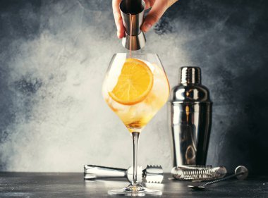 Aperol spritz kokteyl hazırlanması, barmen acı dökülen Devol, yaz İtalyan düşük alkol soğuk içecek, siyah bar counter arka plan, yaz ruh kavramı. Seçici odak