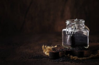 Siyah quinoa tohumlar dökülür cam kavanoz, vintage mutfak masa artalanını, seçici odak