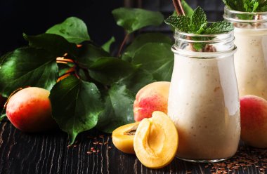 Arka plan, kopya alanı, seçici odak sağlıklı kayısı smoothies taze meyveleri ve keten tohumu, cam şişelerde, rustik mutfak masa 