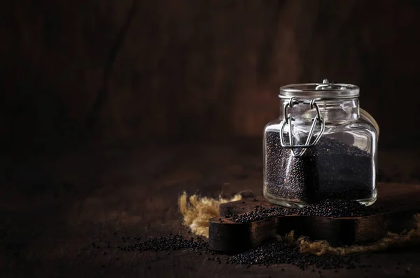 Biji Quinoa Hitam Dituangkan Dari Botol Kaca Latar Belakang Tabel — Stok Foto