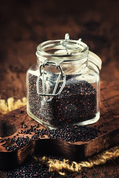 Zwarte Quinoa Zaden Gegoten Uit Glazen Pot Vintage Keuken Tabelachtergrond — Stockfoto