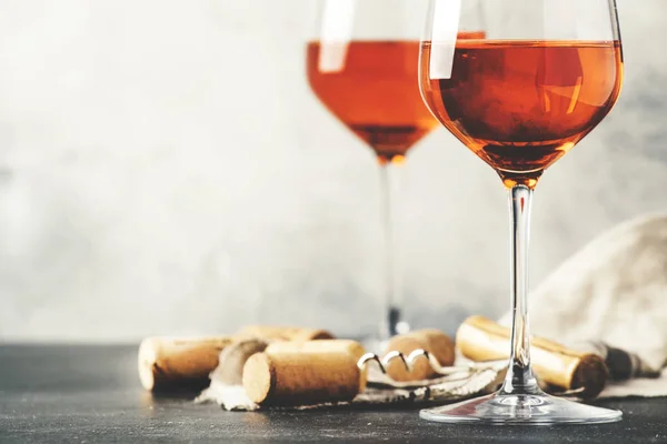 Trendy food and drink, orange wine in glass, gray table background, space for text, selective focus, vintage toned image