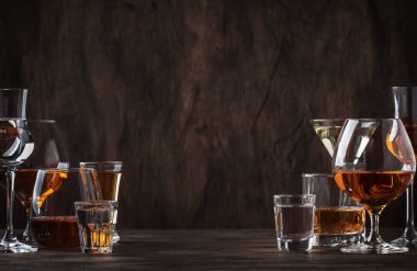 Seçim zor güçlü alkollü içecekler büyük gözlük ve bardak içinde assortent: votka, konyak, tekila, brendi ve viski, grappa, likör, vermut, tentür, ROM. Vintage bar counter arka plan, seçici odak, kopya alanı