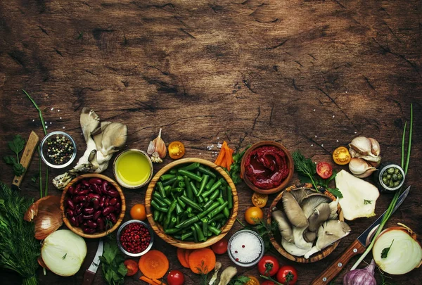 Food cooking background, ingredients for preparation vegan dishes, vegetables, roots, spices, mushrooms and herbs. Healthy food concept. Rustic wooden table background, top view. Copy space