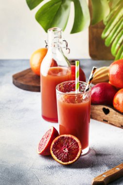 Yaz meyve suyu veya alkolsüz serinletici sağlıklı kokteyl veya taze sıkılmış kırmızı Sicilya portakal, parlak ışık masa artalanını içki. Seçici odak