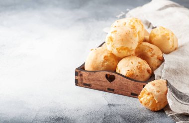 İştah açıcı ev yapımı altın peynirli çörekler gri mutfak masa arka plan, seçici odak üzerinde. Dergi tarzı. Metin için yer