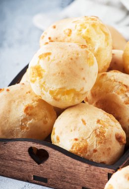 İştah açıcı ev yapımı altın peynirli çörekler gri mutfak masa arka plan, seçici odak üzerinde. Dergi tarzı. Metin için yer