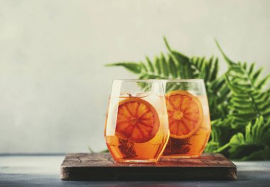 Aperol spritz köpüklü şarap, likör, buz küpleri ve kırmızı turuncu - şarap cam kokteyl yaz İtalyan hafif alkollü içki, gri taş bar counter arka plan araçları, seçici odak ile