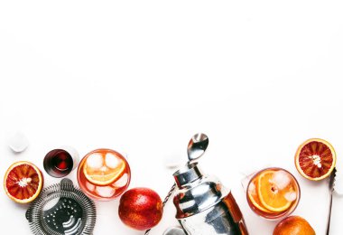 Kuru cin, kırmızı vermut ve kırmızı acı, portakal ve buz küpleri ile popüler alkollü kokteyl Negroni. Beyaz arka plan, araçlar, üstten görünüm, metin için yer.