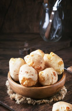 Ev yapımı tatlı muhallebi buns, ahşap kase, rustik mutfak masa arka plan, metin, seçici odak için yer