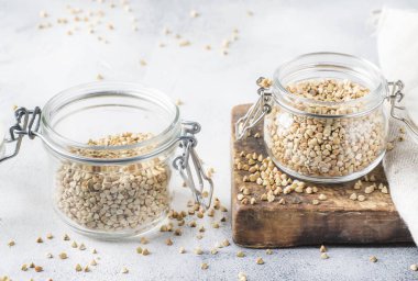 Cam Kavanoz, sağlıklı vegan gıda veya ham diyet kavramı, gri mutfak masa artalanını, seçici odak yeşil buğday