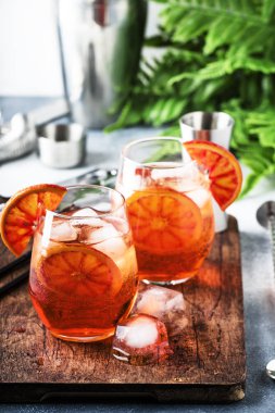 Aperol spritz köpüklü şarap, likör, buz küpleri ve kırmızı turuncu - şarap cam kokteyl yaz İtalyan hafif alkollü içki, gri taş bar counter arka plan araçları, seçici odak ile