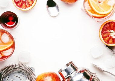 Kuru cin, kırmızı vermut ve kırmızı acı, portakal ve buz küpleri ile popüler alkollü kokteyl Negroni. Beyaz arka plan, araçlar, üstten görünüm, metin için yer.