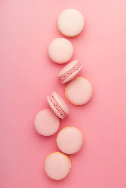 Pink yellow macaroons on soft pink background table, place for text, minimalism style, top view