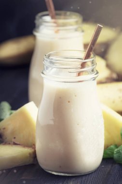 Ananas ve muz cam şişeler, koyu arka plan, seçici odak smoothies