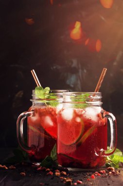 Meşrubat kavanoz, karanlık tablo arka plan, seçici odak ferahlatıcı soğuk yaz kırmızı çay buz, kireç ve nane,