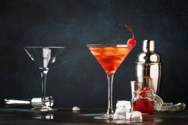 Bourbon, kırmızı vemuth, acı ile klasik alkollü kokteyl Manhattan, buz ve kokteyl kiraz cam, gece bar arka plan, metin için seçici odak yerleştirin