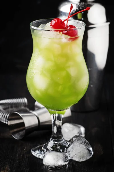ハリケーンのガラス 暗いバーのカウンターの背景 選択と集中にマラスキーノ チェリーと緑のアルコール Ocktail — ストック写真