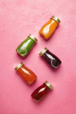 Çok renkli Detoks vegan sebze suları ve kopyalama alanı, top görünümü smoothies pembe tablo, pişmemiş yiyecek ve temiz gıda kavramı, içki arka plan, cam şişelerde
