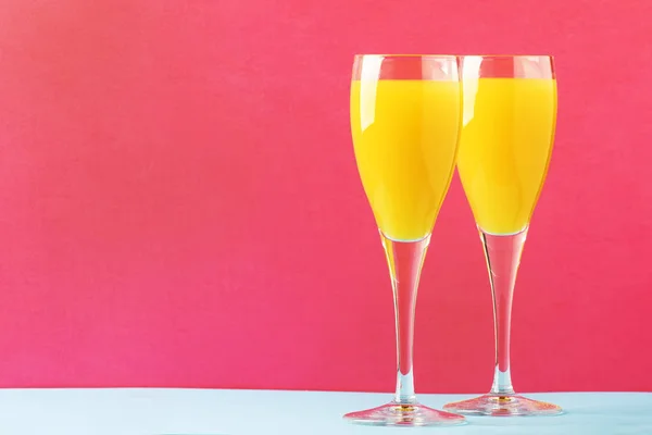 お祝いアルコール カクテル ミモザ オレンジ ジュースと冷たい辛口のシャンパンやスパーク リング ワインはグラス ピンク Treandy 背景とテキスト — ストック写真
