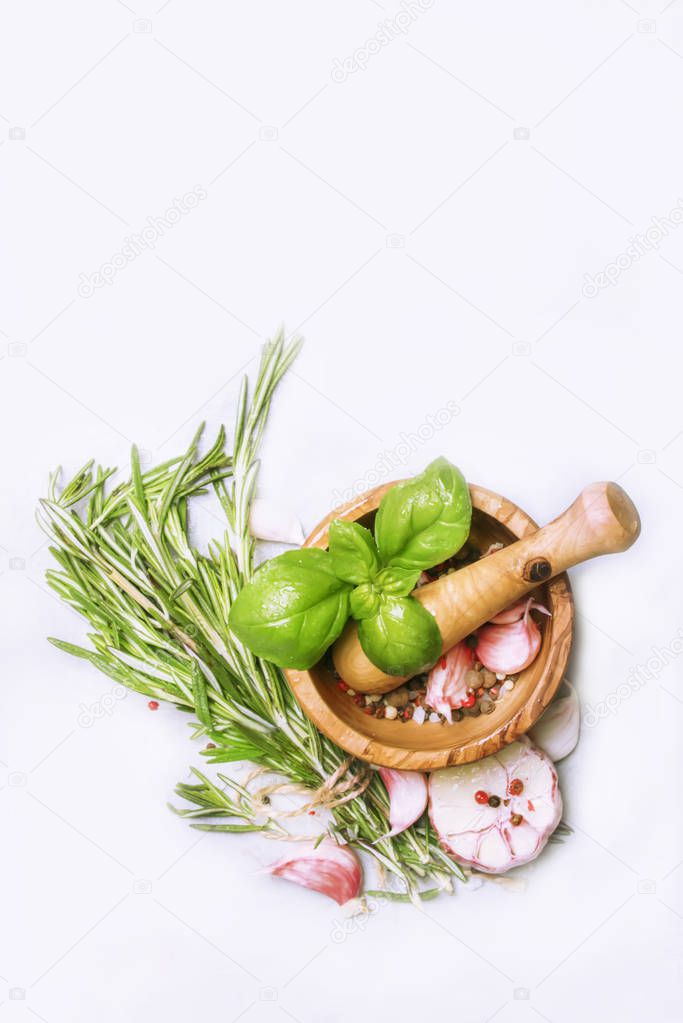 Spice mix, fresh spicy herbs: rosemary, green basil, red garlic, assorted pepper on gray kitchen table, food cooking background, top view, vertical