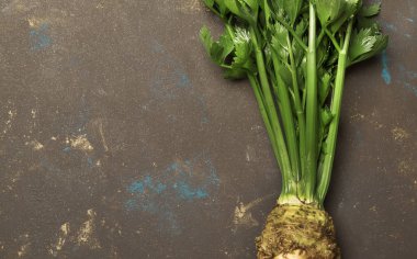 Kök kereviz yeşil kaynaklanıyor, koyu arka plan, üstten görünüm