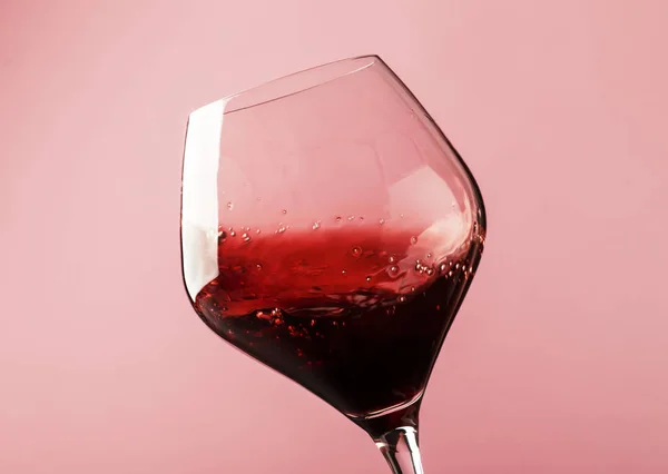 Dry Red Wine Splash Glass Pink Background Defocused Motion Image — Stock Photo, Image