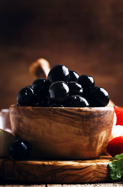 Španělské Černé Olivy Olivové Dřevěné Misce Pozadí Stolu Rustikální Kuchyně — Stock fotografie