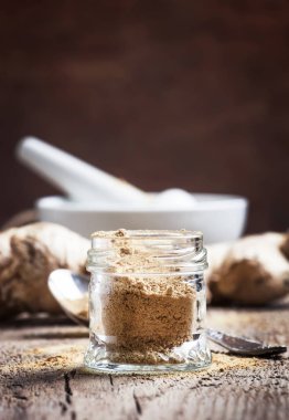 Cam Kavanoz ve taze zencefil kökü, vintage Ahşap mutfak masa artalanını, seçici odak zemin zencefil