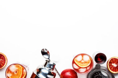 Kuru cin, kırmızı vermut ve kırmızı acı, portakal dilimi ve buz küpleri ile trendy alkollü kokteyl Negroni. Beyaz arka plan, araçlar, üstten görünüm, kopya alanı
