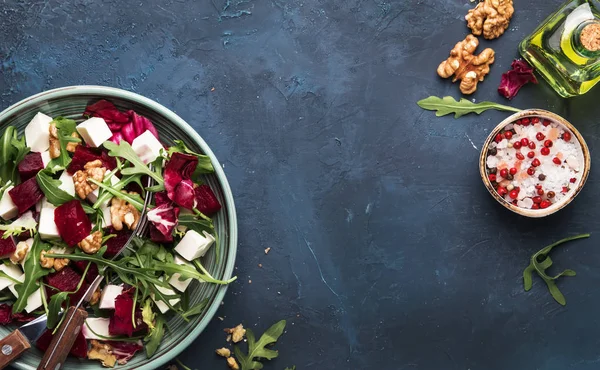 甜菜やテーブル ビート サラダ新鮮なルッコラ トレビス ソフトチーズ フォーク ドレッシング ブルー キッチン テーブル背景 — ストック写真