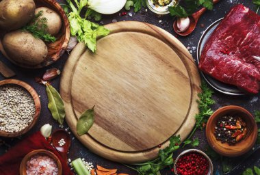 Rustik ahşap kesme tahtası ile Vintage mutfak masa arka planda pişirme çorbası için taze organik sebzeler, malzemeler, baharatlar ve et. Üst görünüm, metin için yer. Sağlıklı pişirme ve yeme konsepti