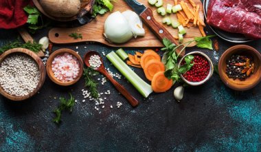 Rustik ahşap kesme tahtası ile Vintage mutfak masa arka planda pişirme çorbası için taze organik sebzeler, malzemeler, baharatlar ve et. Üst görünüm, metin için yer. Sağlıklı pişirme ve yeme konsepti