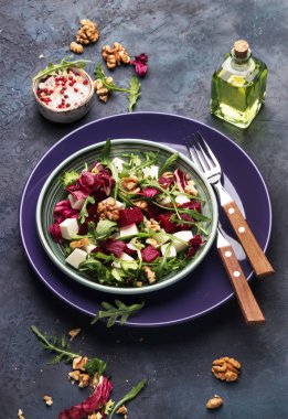 Taze roka, radicchio, yumuşak peynir ve ceviz plaka çatal, sosu ile baharat mavi mutfak masa arka planda, kopya alanı, pancar veya kırmızı pancar salatası en iyi görünümü
