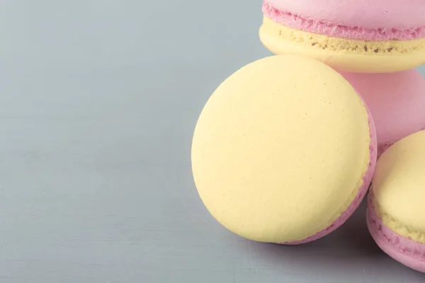 ピンクの灰色青い表の背景に黄色のマカロン ケーキ テキスト トレンディなミニマリズム スタイル 選択と集中のための場所 — ストック写真