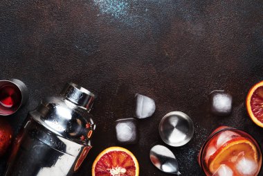 Trendy iç, Kuru cin, kırmızı vermut ve kırmızı acı, portakal dilimi ve buz küpleri ile alkollü kokteyl Negroni. Brown bar counter arka plan, araçlar, üstten görünüm, yaz ruh kavramı, kopya alanı bar