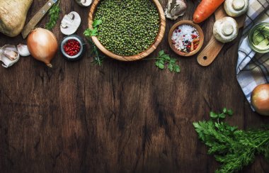 Yemek pişirme arka plan. Sebzeler, baharatlar ve otlar, ahşap mutfak masası arka plan, metin için yer ile yeşil mercimek hazırlamak için Malzemeler. Vegan veya vejetaryen gıda oncept. Üst görünüm, düz yatıyordu 